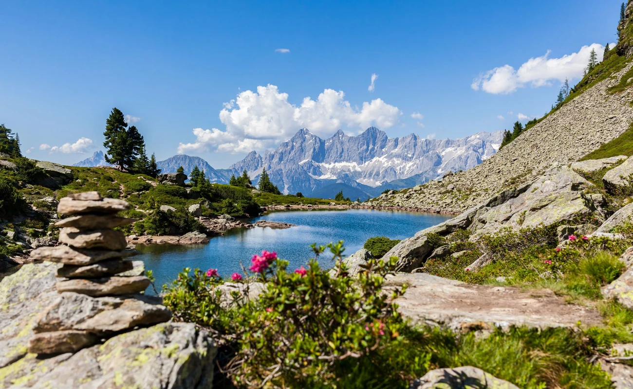 Lake Spiegelsee Mittersee on Reiteralm and distant mountain range Dachstein in Styria, Austria