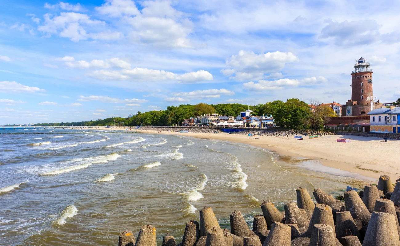 Lighthouse and beautiful white sand beach and blue sea in Kolobrzeg, Baltic Sea coast, Poland