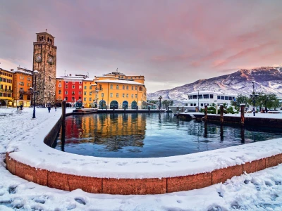 Beautiful view of Riva del Garda on a winter day with lots of snow, View of the beautiful Lake Garda in a snowy day surrounded by mountains, Trentino Alto Adige region