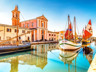 Church and ancient saiboats on Leonardesque gat in Cesenatico in Italy